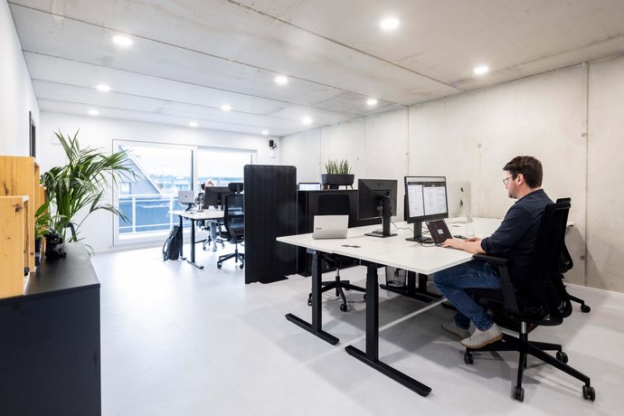 AB3 in Bad Waldsee Mann sitzt an Co-Working Schreibtisch bei Alpenblickdrei in Bad Waldsee