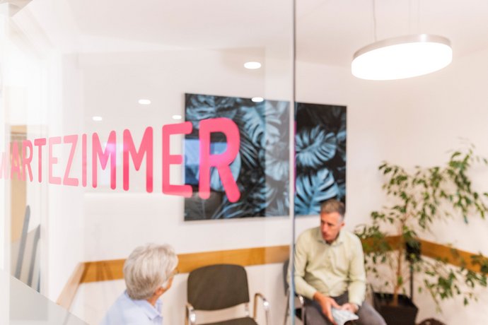 Wartezimmer Dr. Schön & Kollegen Ein Mann sitzt in einem Wartezimmer