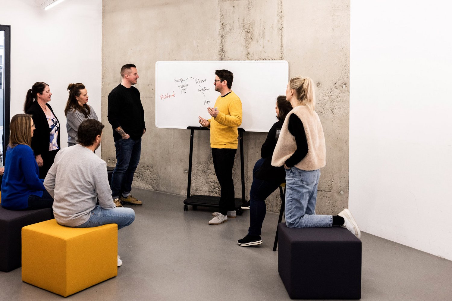 Ideen sammeln am Whiteboard Teammitglied der Alpenblickdrei Werbeagentur schreibt Notizen an ein Whiteboard während eines Workshops.